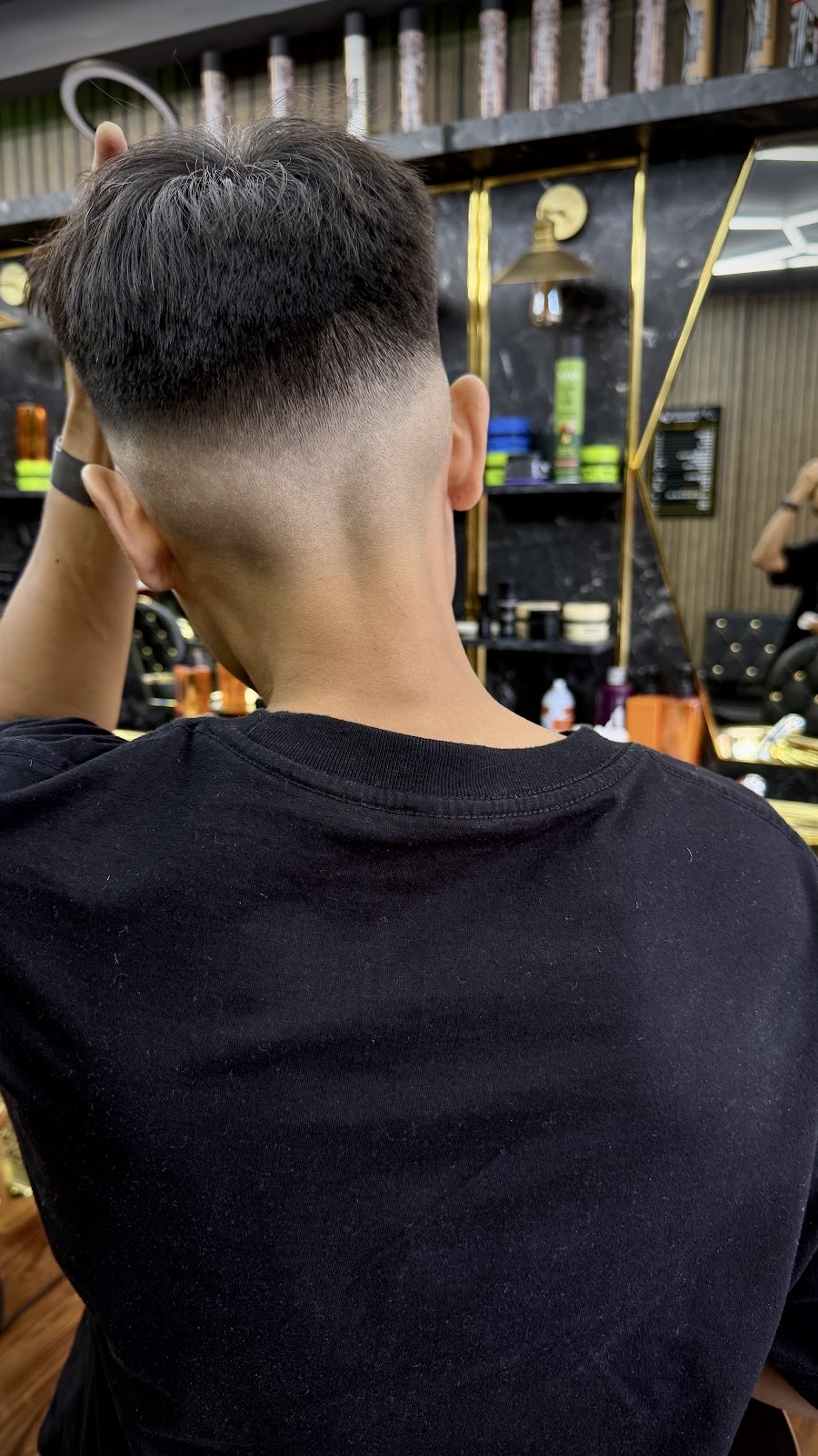 Back of the head close-up of a sharp mid skin fade with a textured dark top